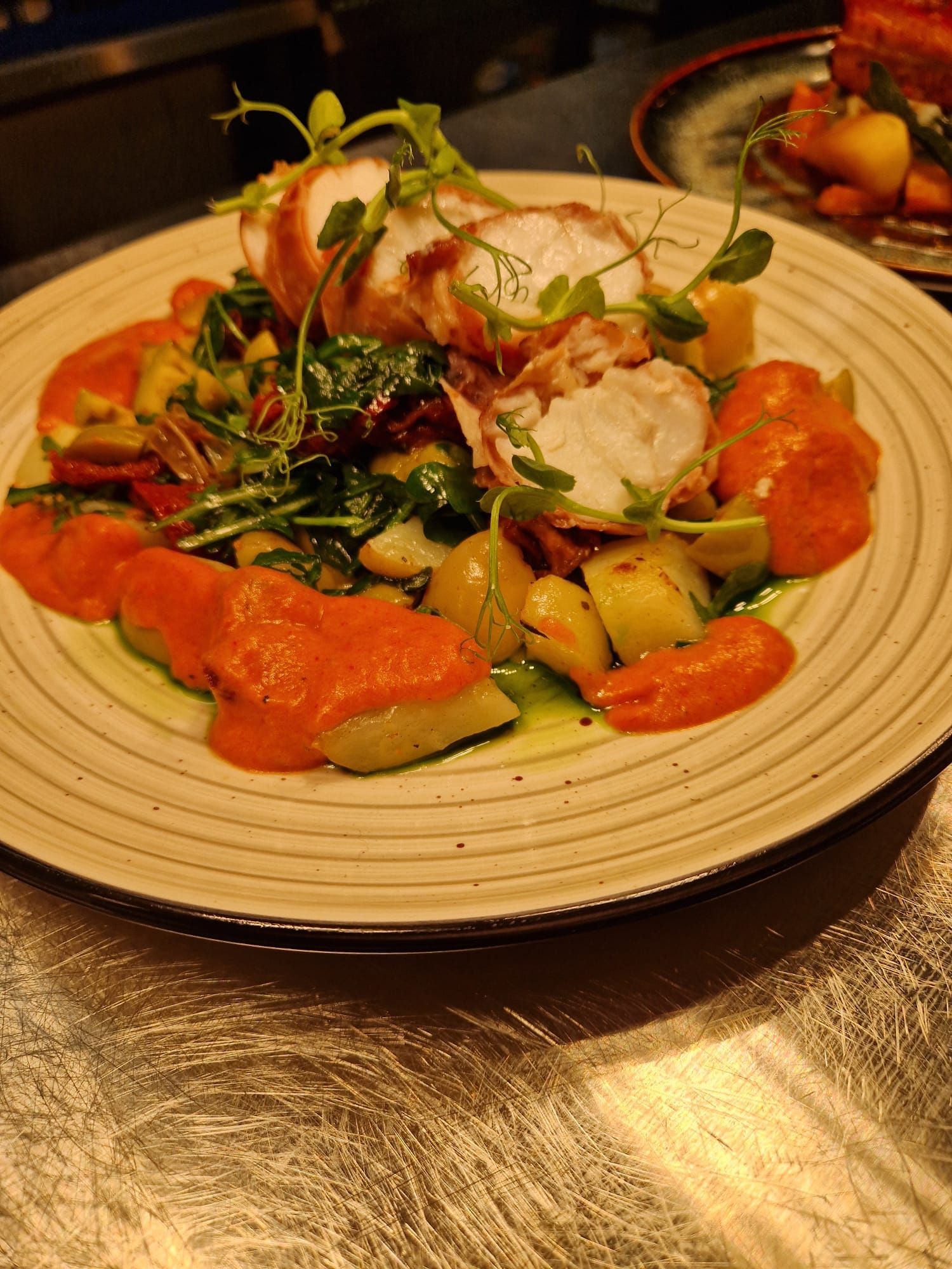 A dish of monkfish wrapped in prosciutto with romesco sauce