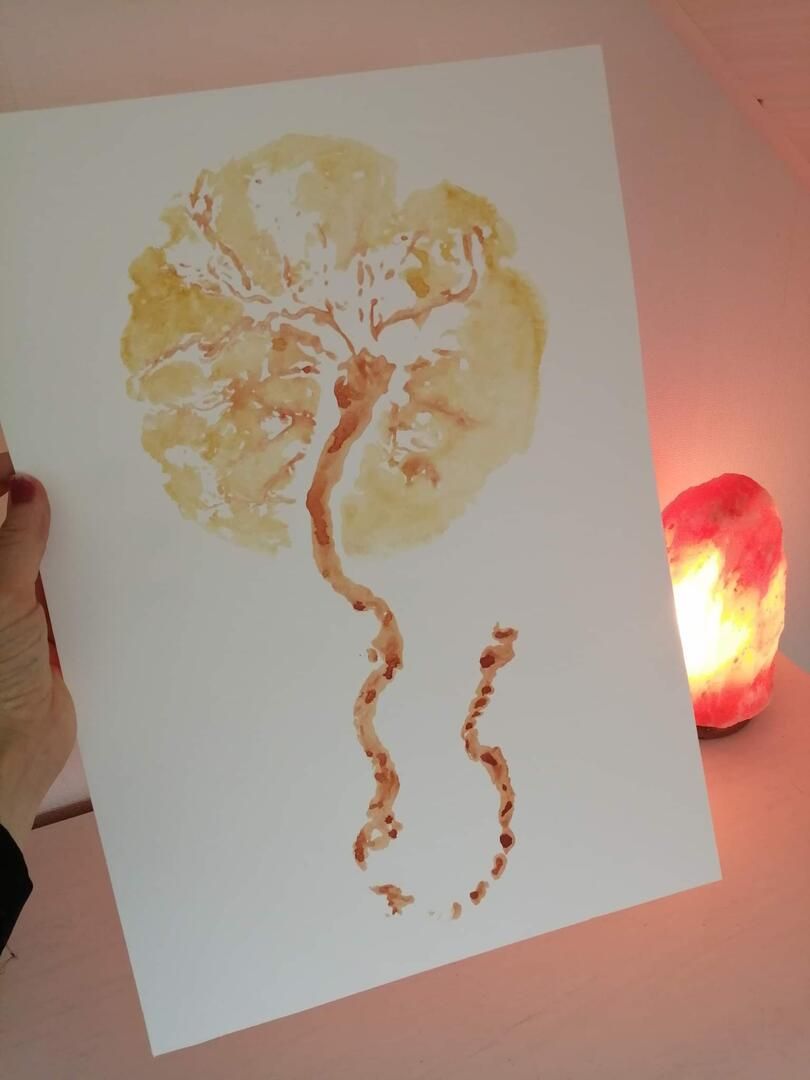 Abstracte aquarel van een gouden boom met een kronkelende stam op wit papier naast een gloeiende rode lamp.