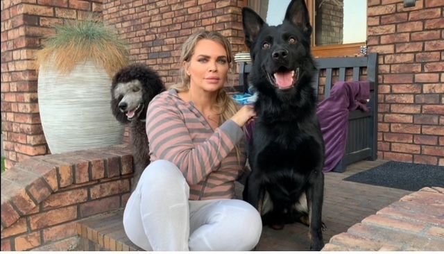 A woman is sitting on a porch with two dogs.