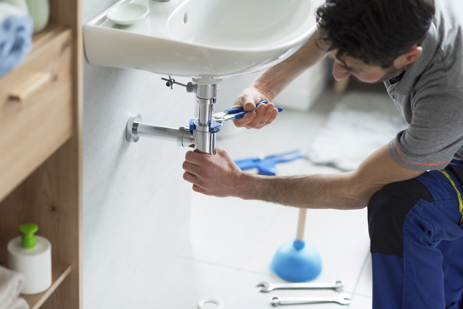 Professional plumber fixing a sink drain, as part of plumbing services. Professional plumber fixing a sink drain, as part of plumbing services.