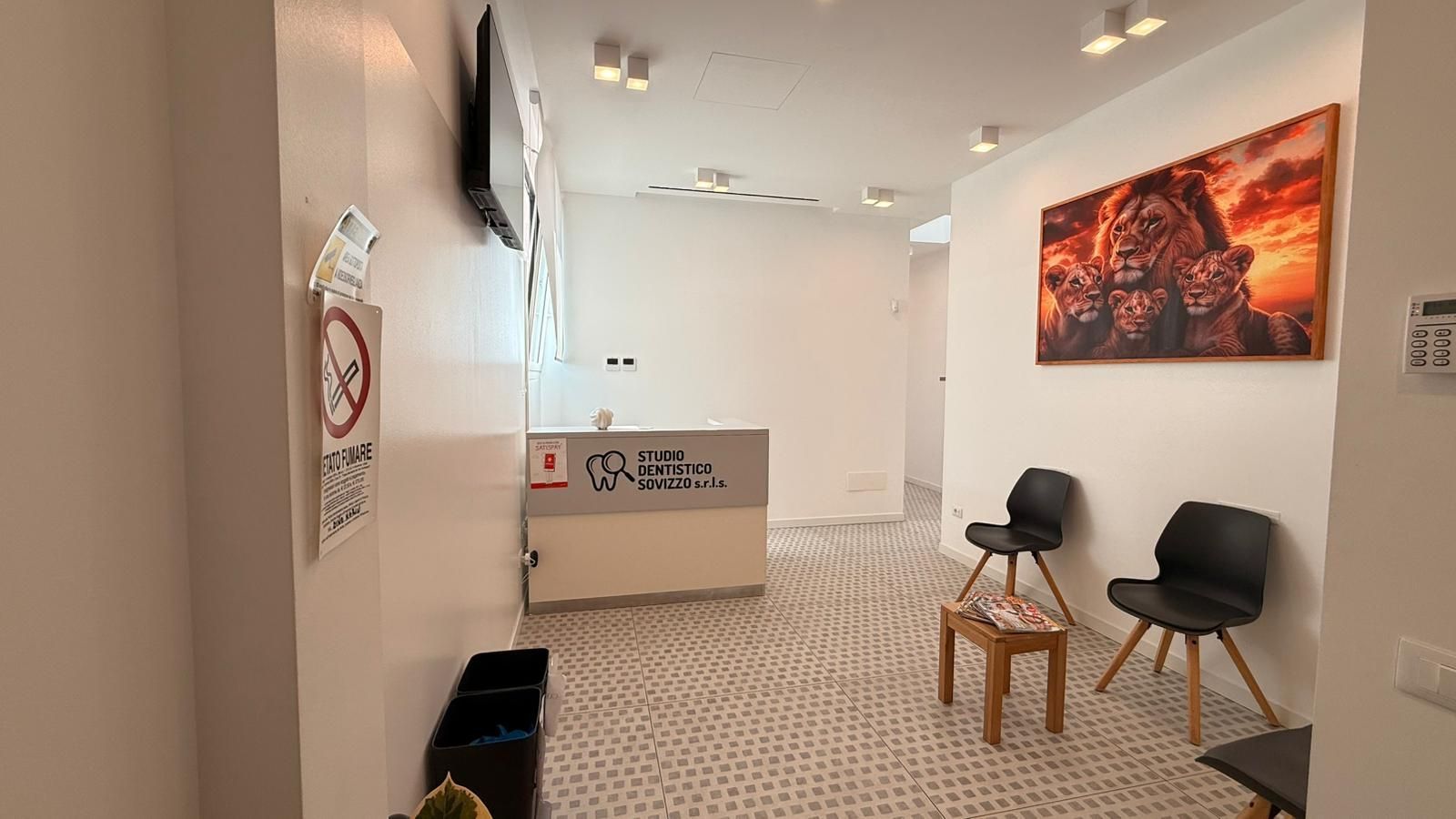 Sala visite odontoiatriche moderna con poltrona, luci a soffitto e apparecchiatura a raggi X.