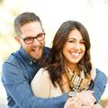 A man wearing glasses is hugging a woman wearing a watch