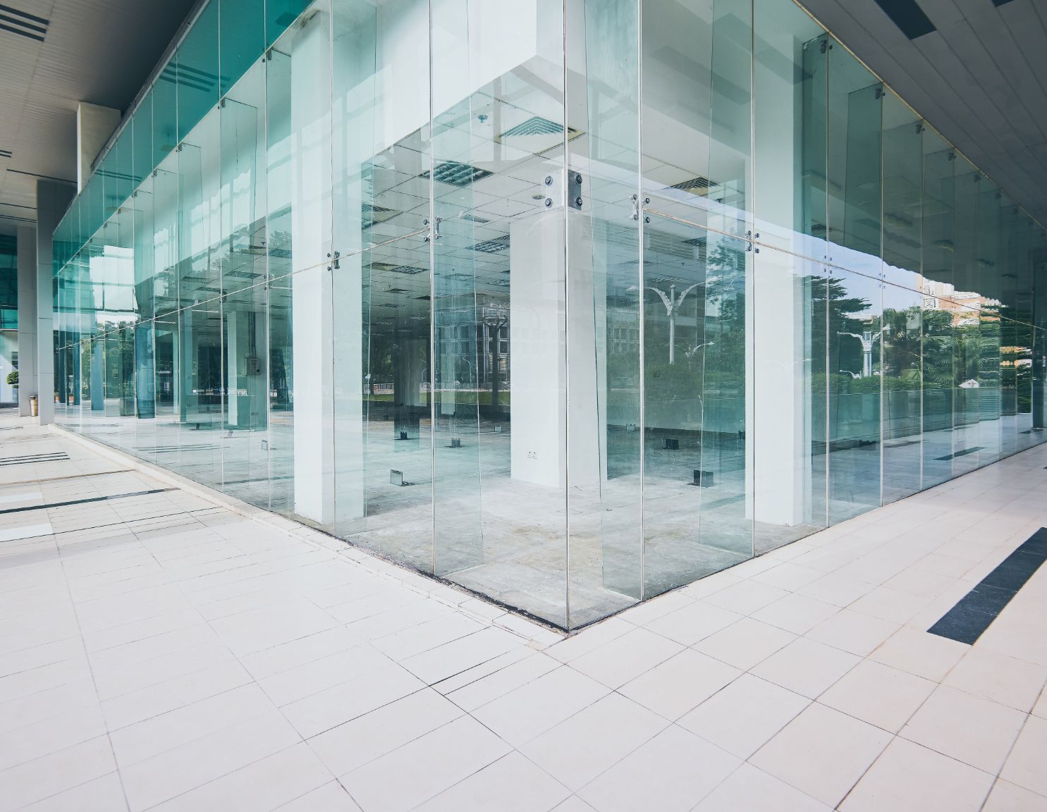Spacious modern atrium with reflective glass walls and a tiled floor