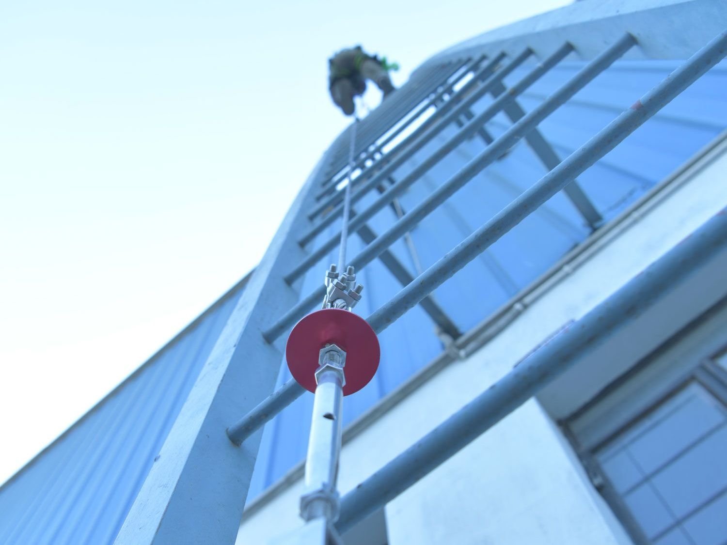 A man on a rope climbs up a building