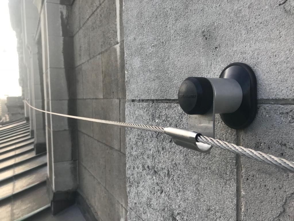 A close up of a rope attached to a brick wall.