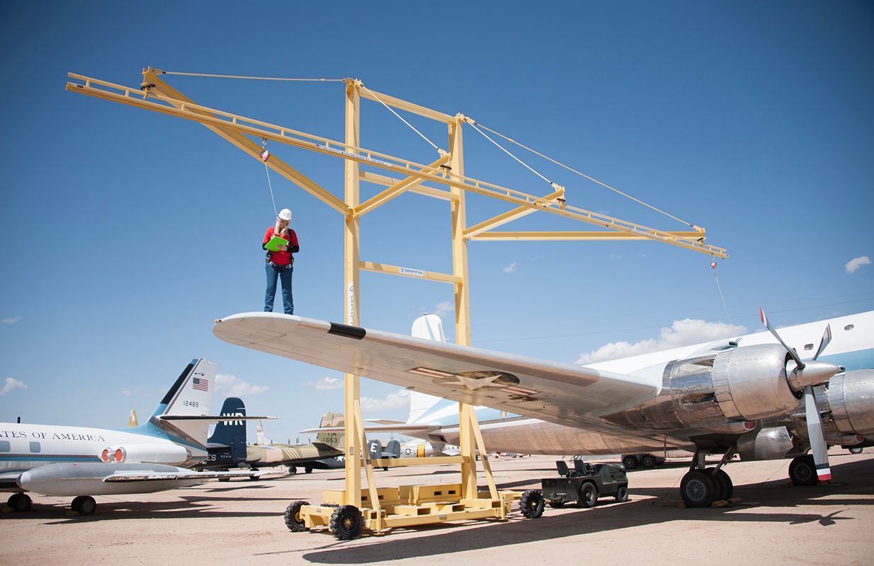 A man is standing on the wing of an airplane. A man is standing on the wing of an airplane.