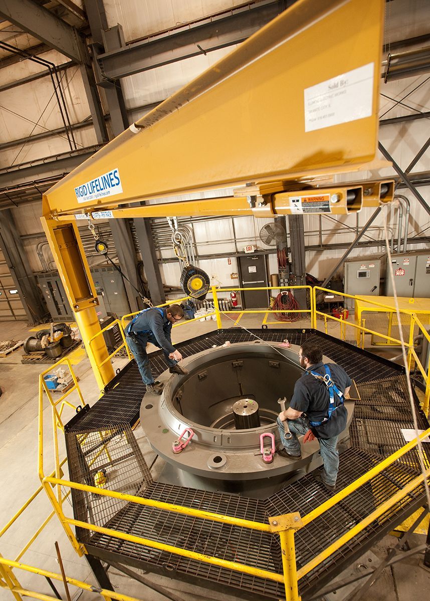A group of men are working on a large machine in a factory.