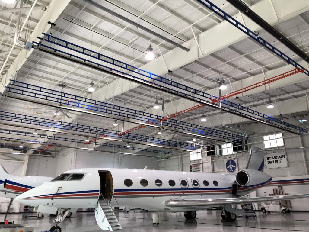 A private jet is parked in a large hangar.