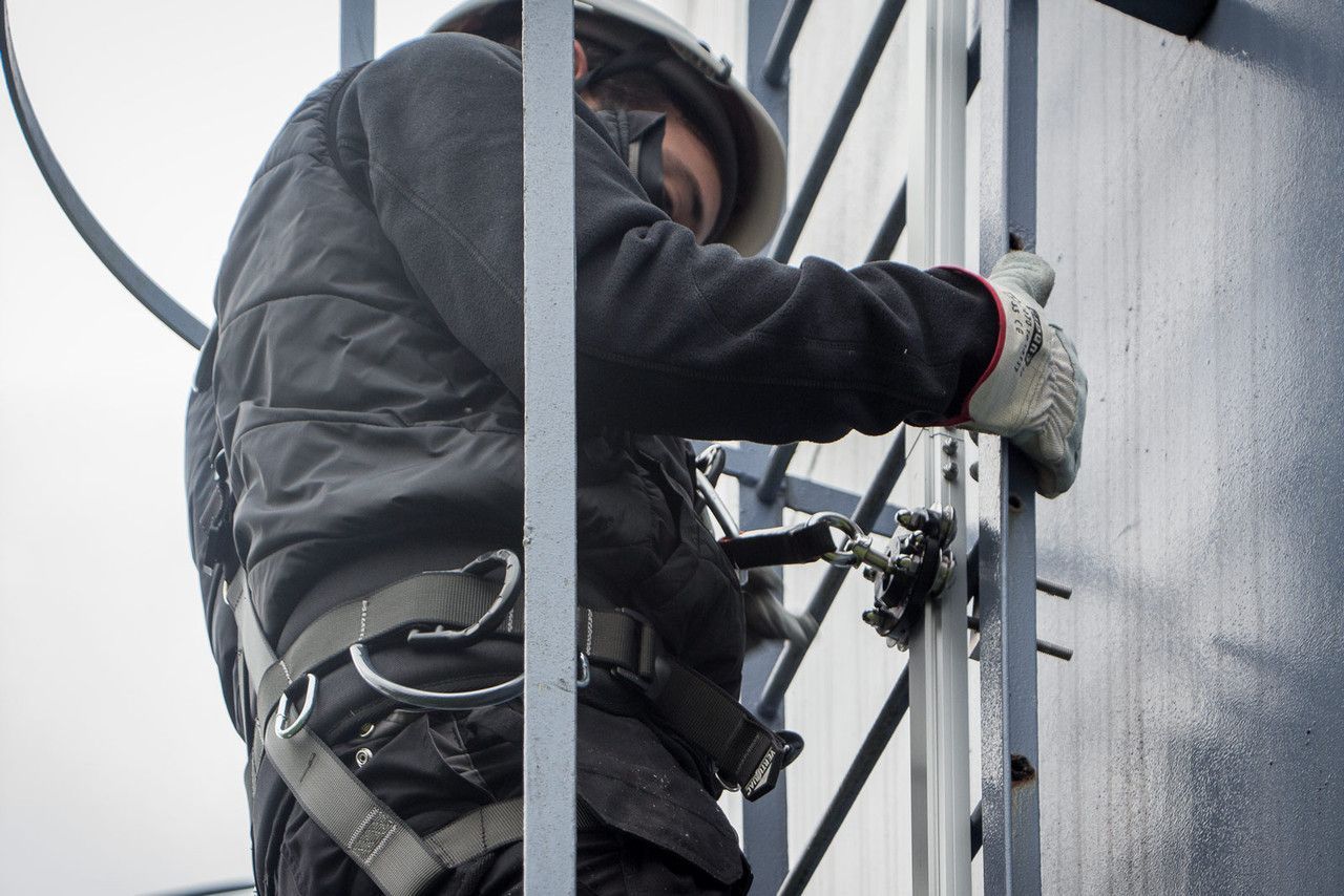 A person is attaching a rope to a metal object. A person is attaching a rope to a metal object.
