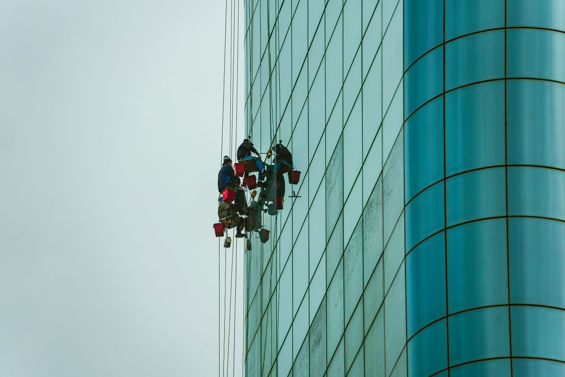 window washing workers suspended on outside of building by window washing Fall protection system