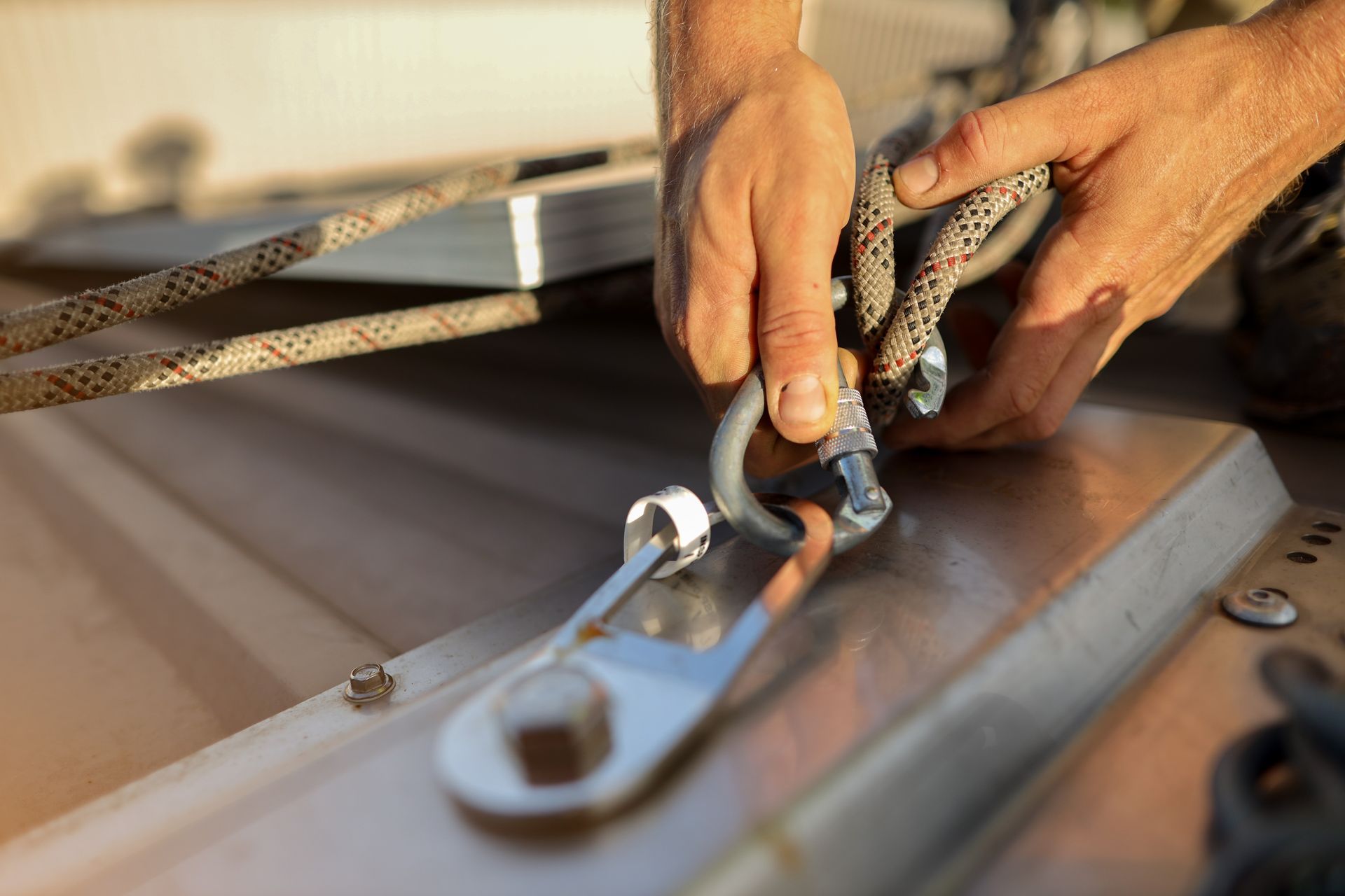 A person is attaching a rope to a metal object. A person is attaching a rope to a metal object.