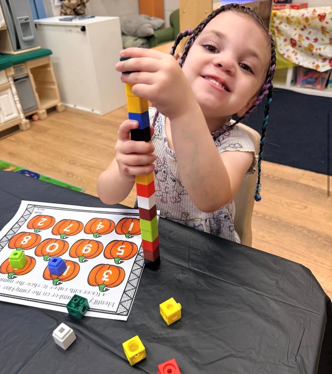 A group of children are playing with plastic blocks at a table.