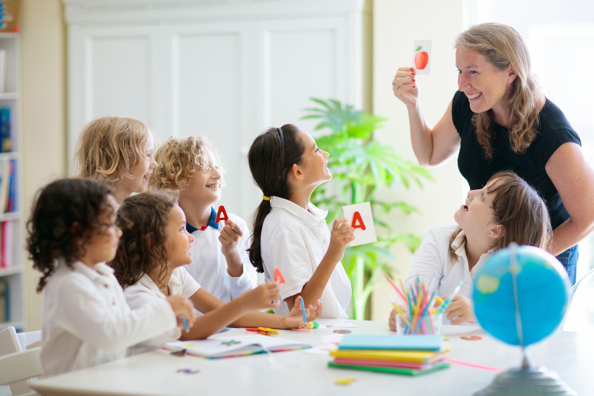 A teacher is teaching a group of children in a classroom.