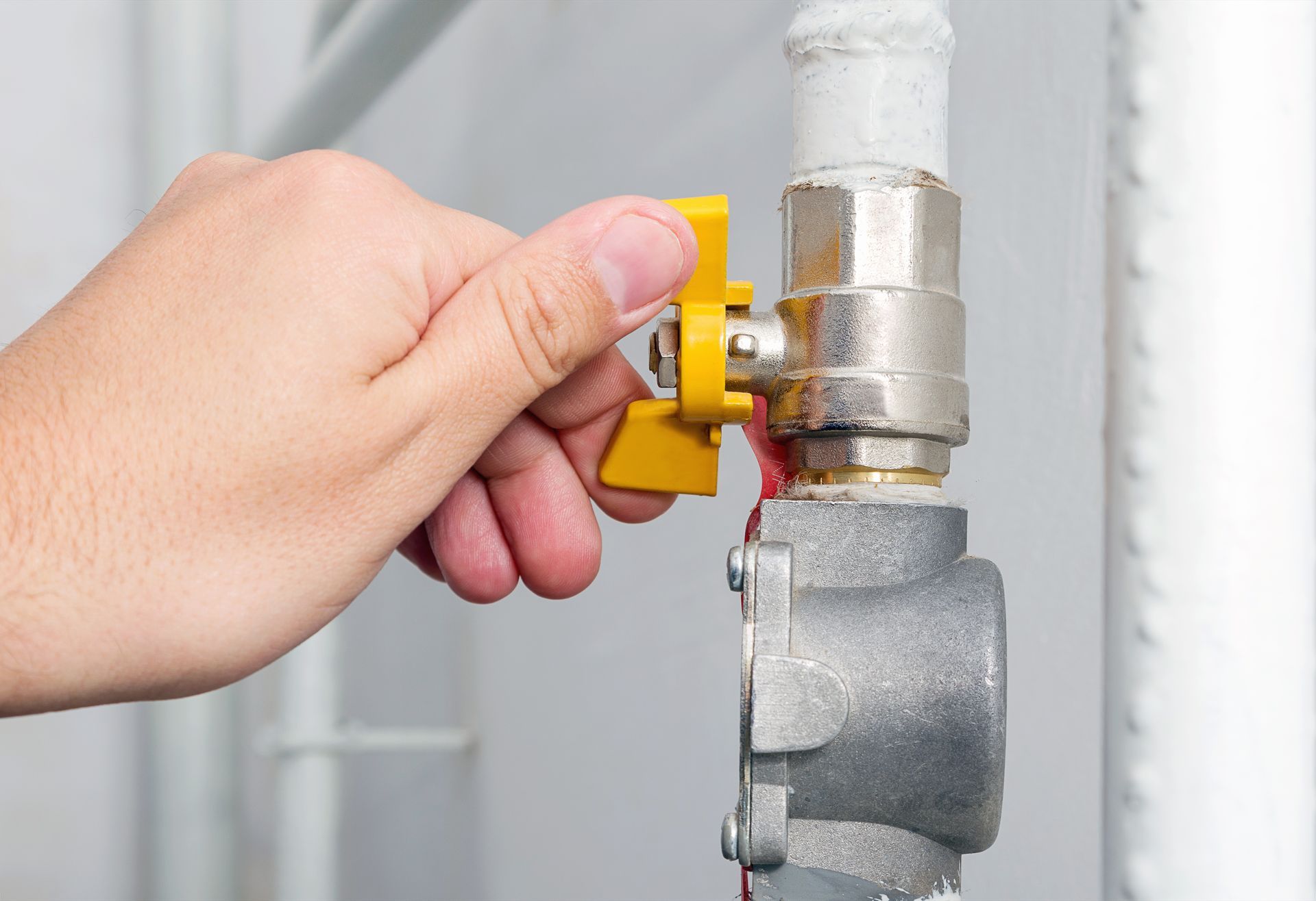 gas line solutions cleveland nc Hand turning a yellow valve on a silver pipe.