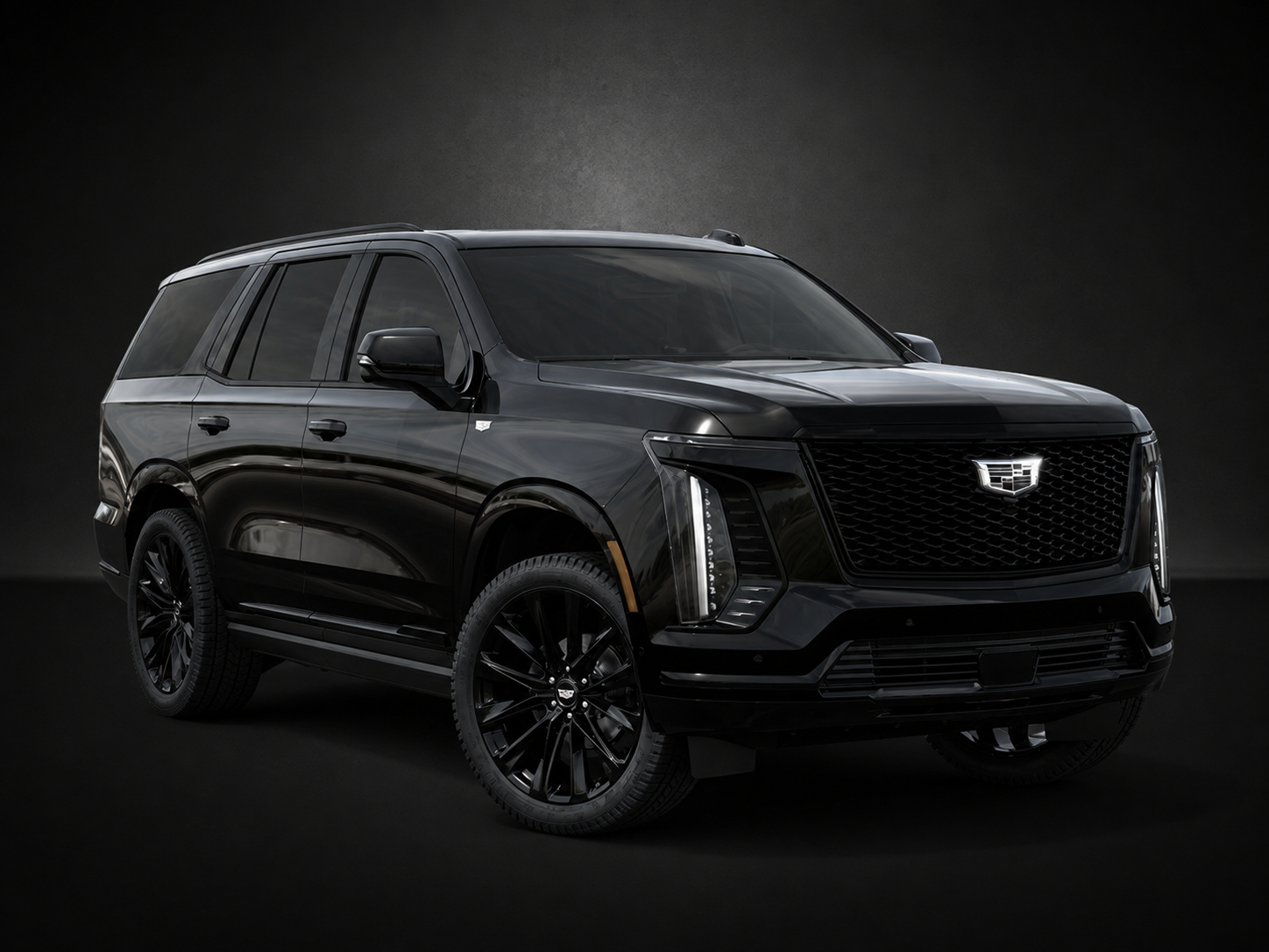A black cadillac xt6 is parked on a black background.