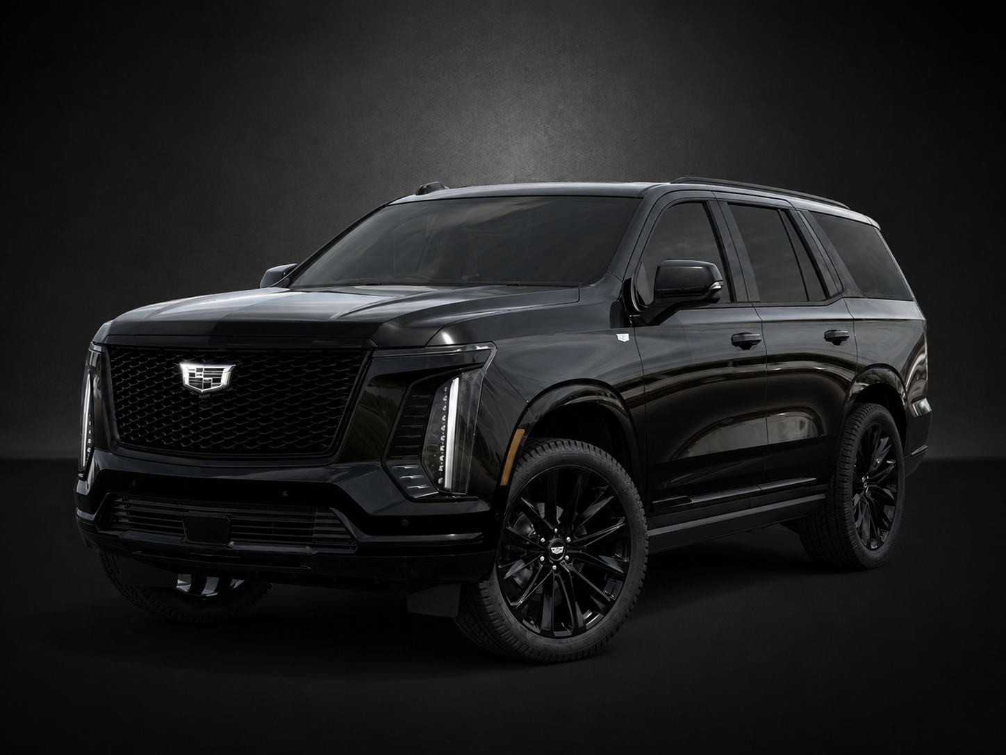 A black cadillac xt6 is parked on a black background.
