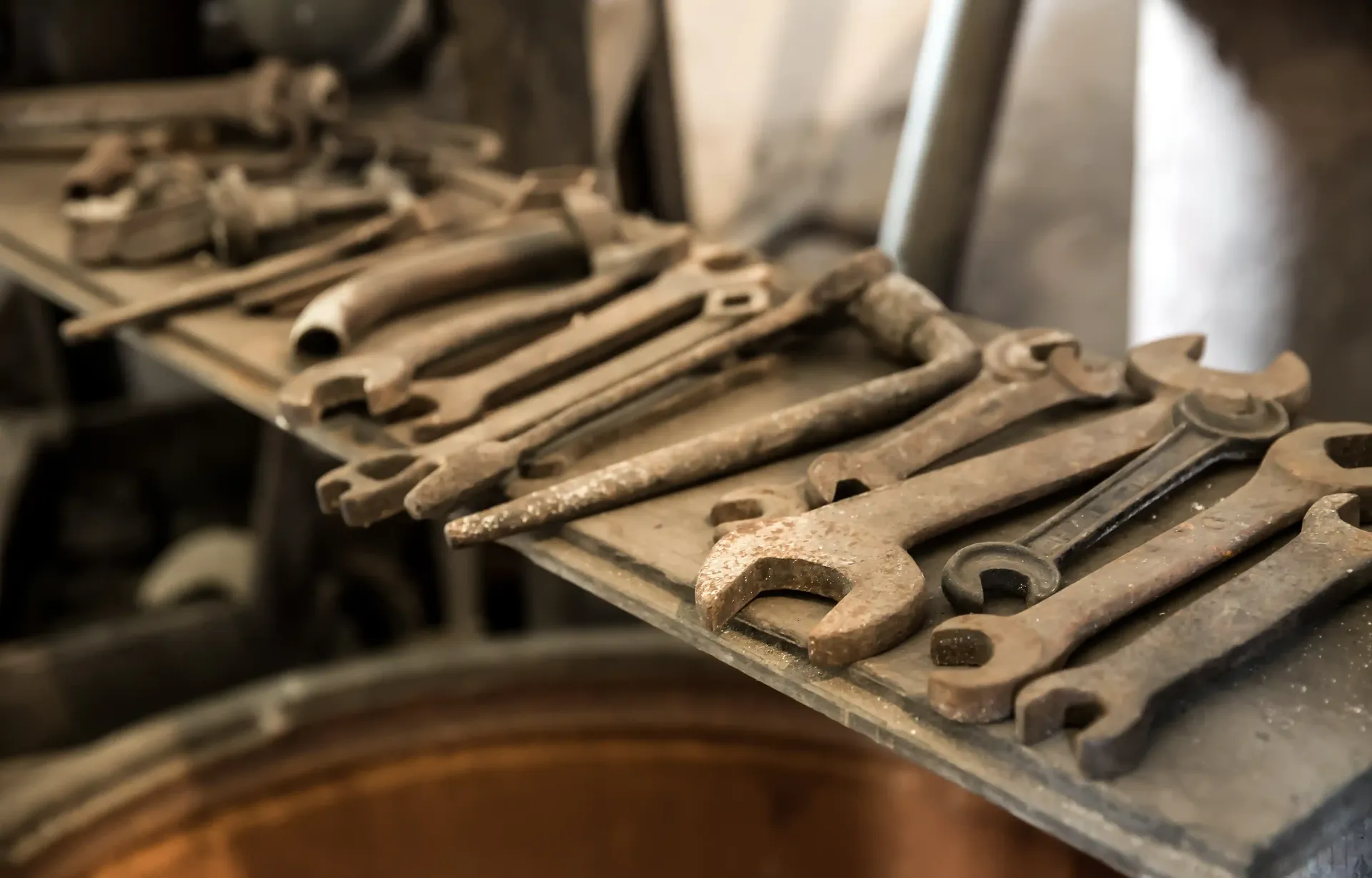 Metal cast letters and tools arranged on a dusty workbench in a workshop