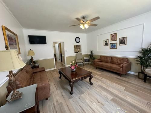 Living room with brown sofas, wooden coffee table, and portraits on the wall.
