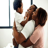 A man and woman are holding a baby in their arms.