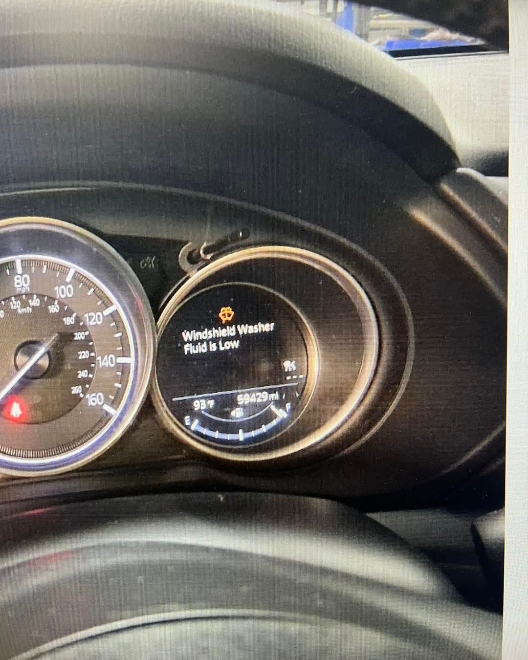 Car dashboard with speedometer and warning lights illuminated in the instrument cluster
