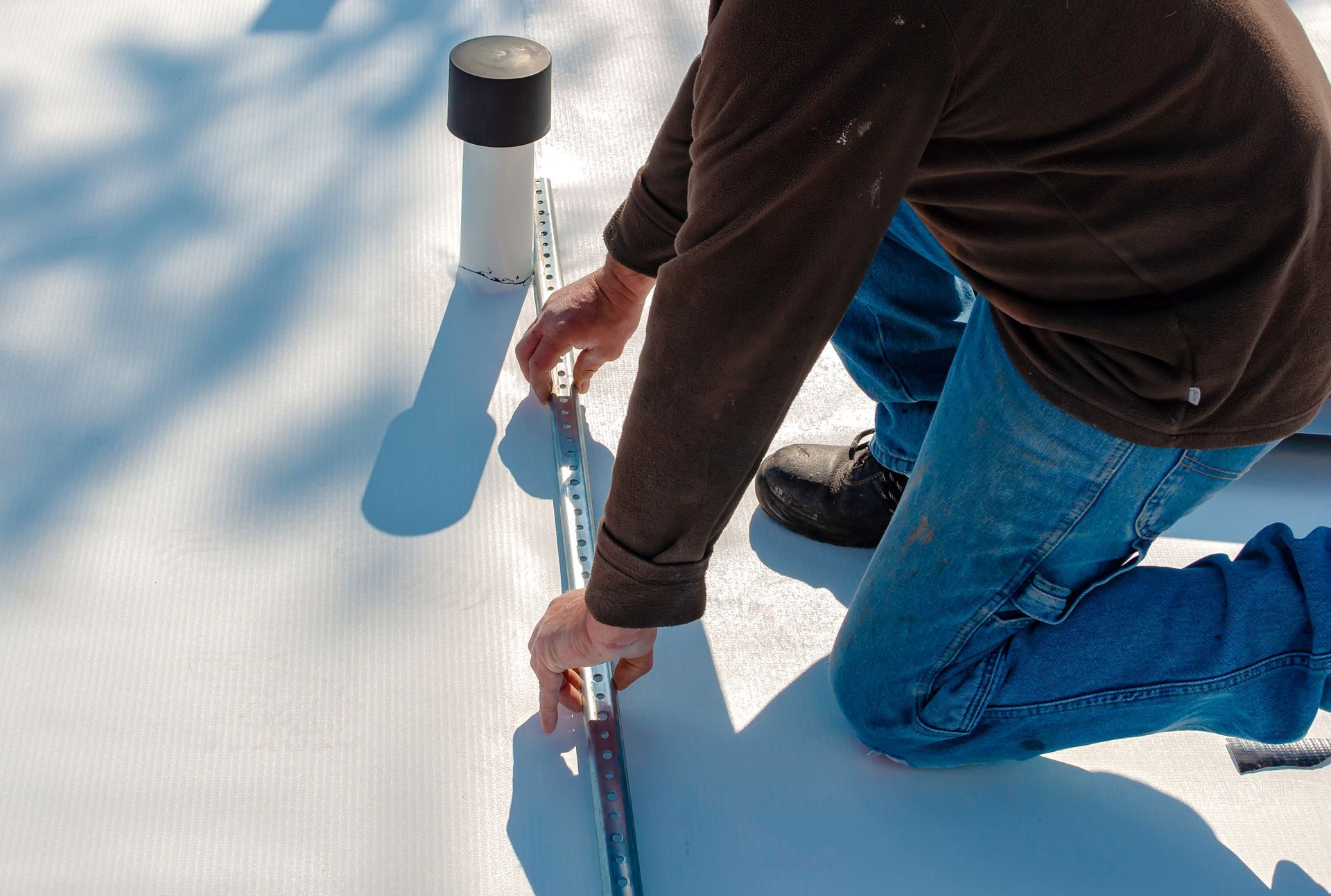 Worker with a heat gun is welding PVC sheets.