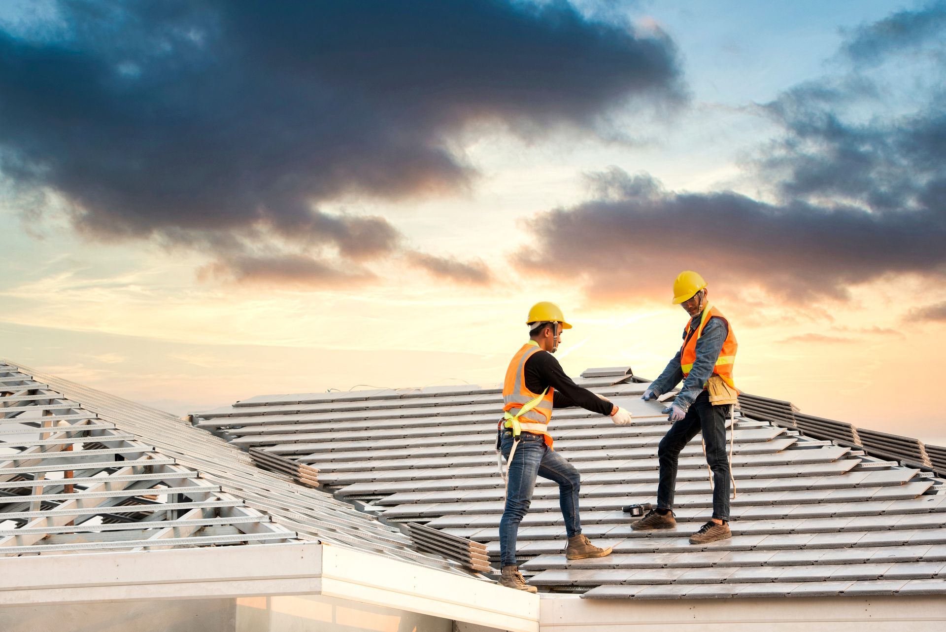Roofers reviewing plans during a roof inspection on a residential roof