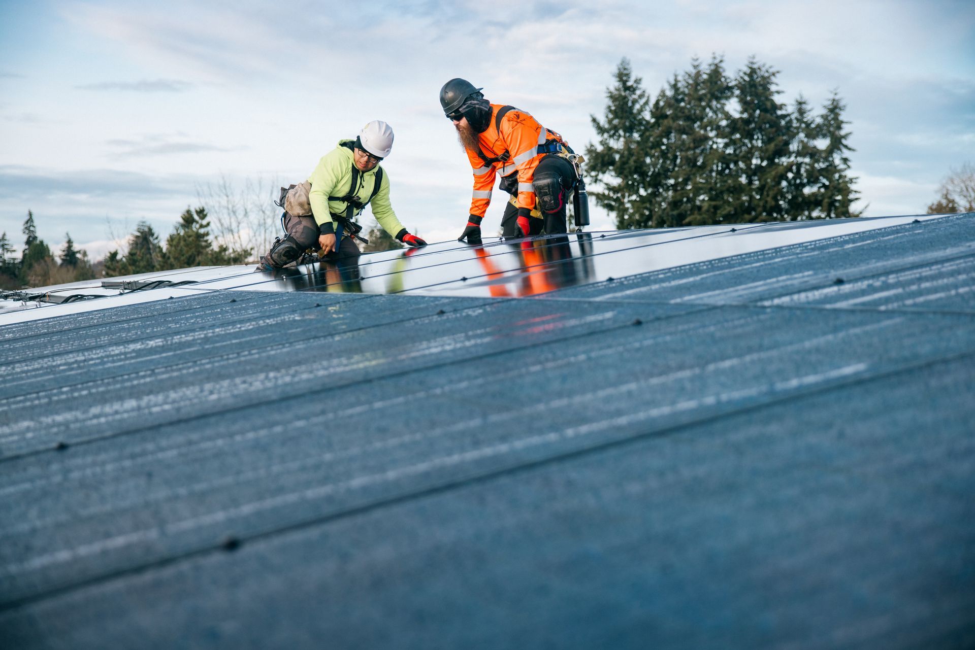 Two men are working on a roof in the snow.
