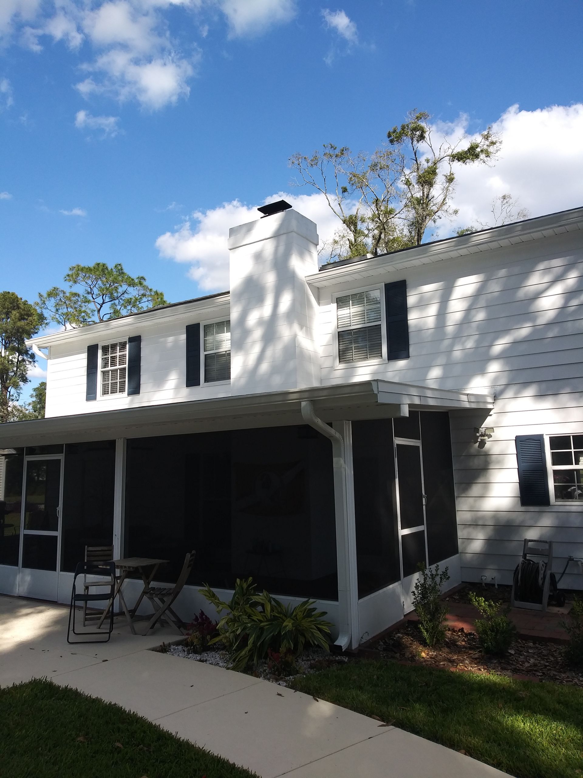 A white house with black shutters and a porch