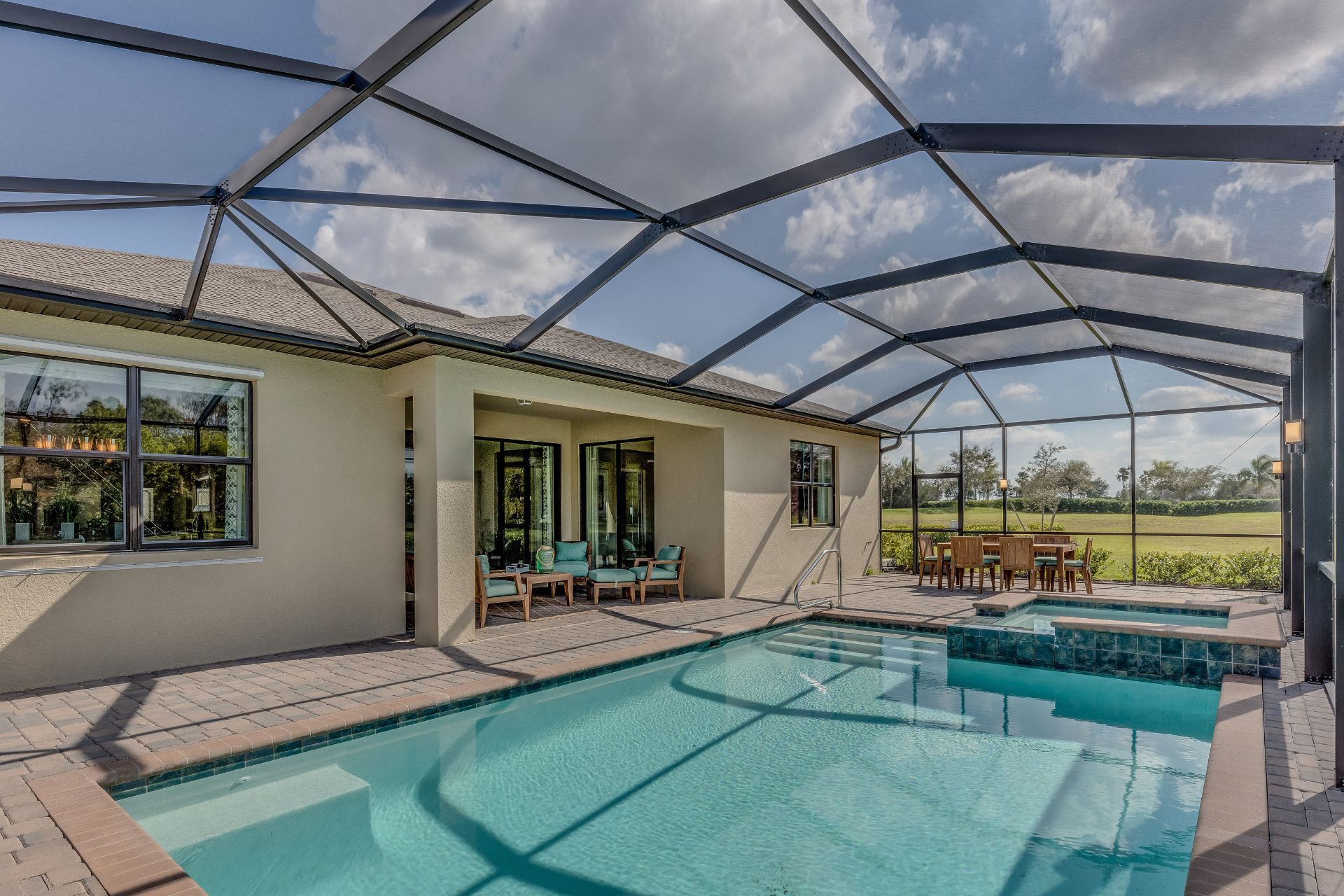 There is a large swimming pool in the backyard of a house.