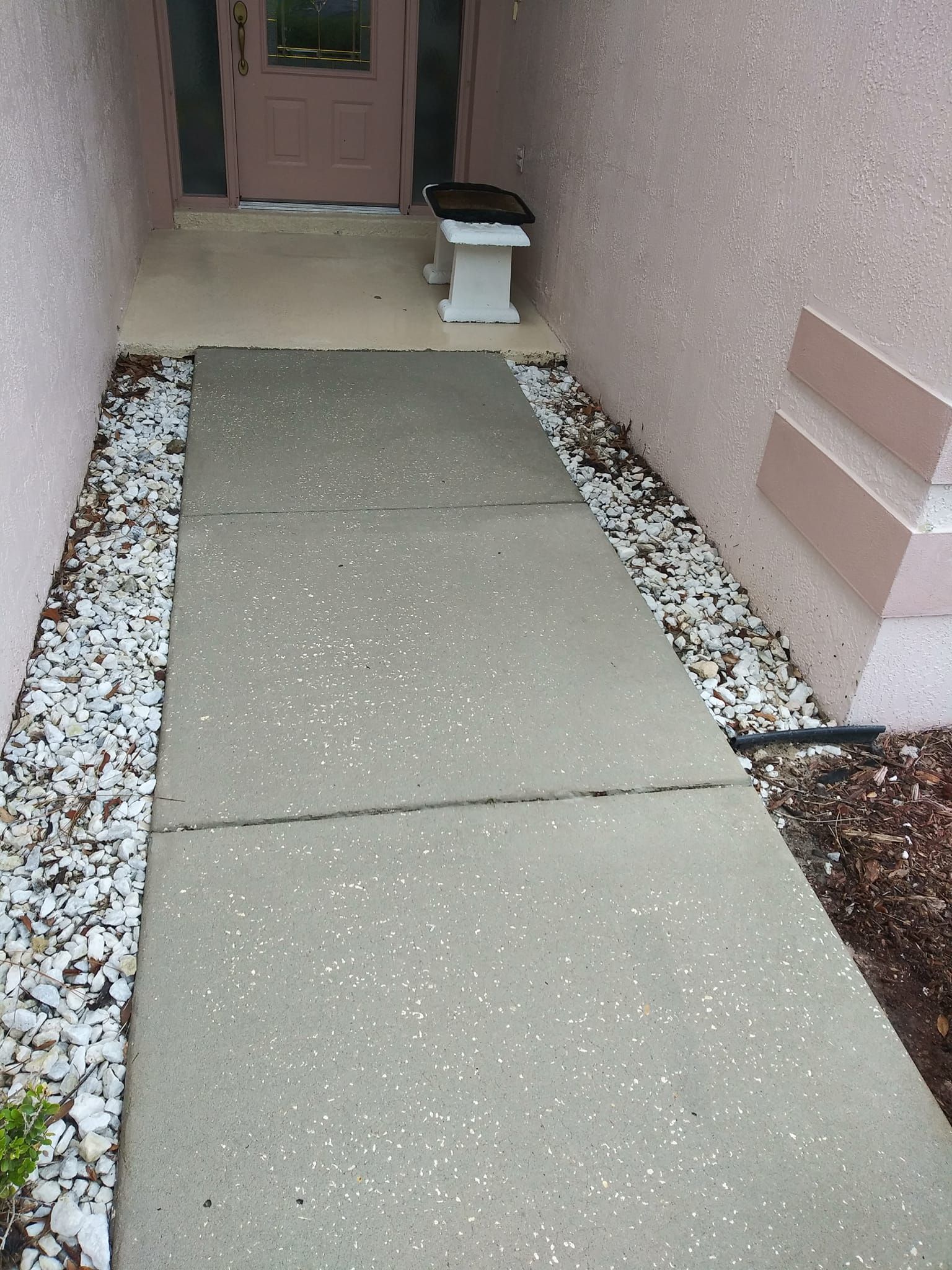 A concrete walkway leading to the front door of a house