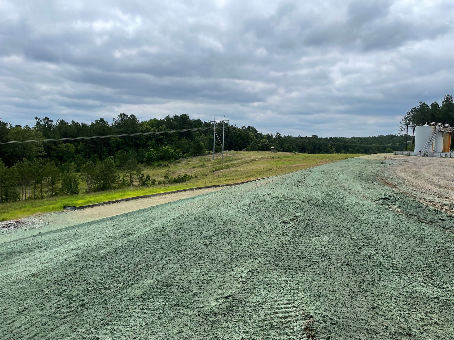 a dirt road with green grass on the side of it