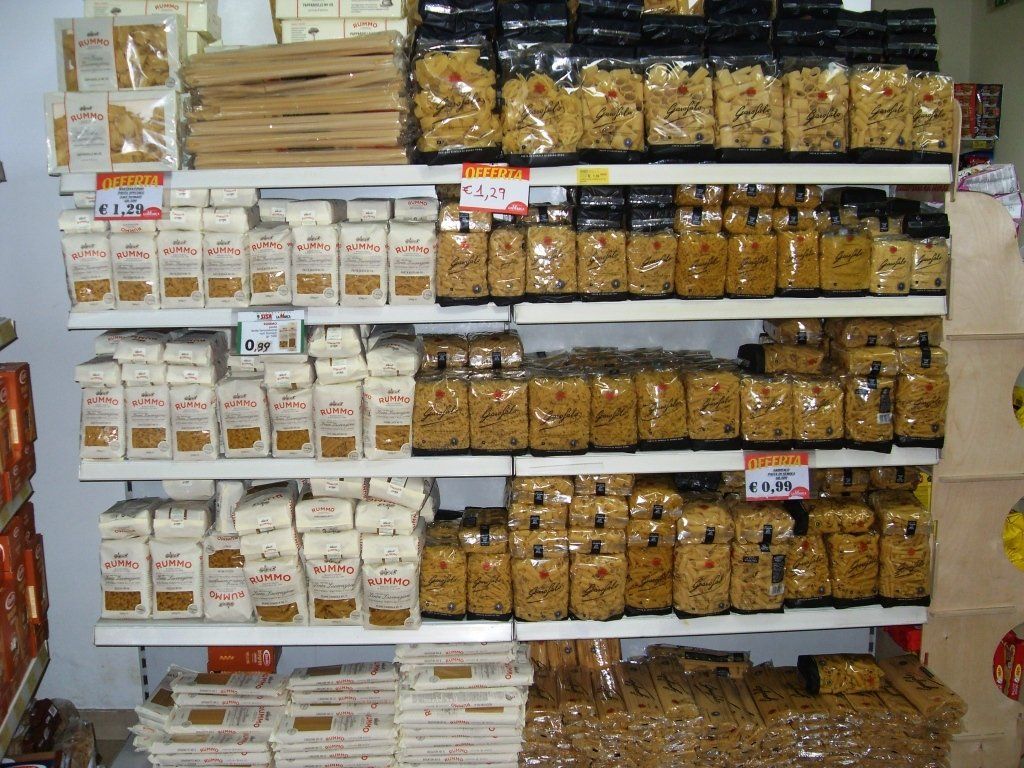 Gli scaffali del negozio sono pieni di file di snack confezionati e prodotti da dispensa.
