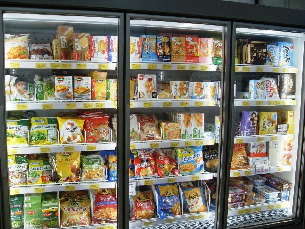 Conservare i banchi frigo pieni di vari alimenti surgelati in una corsia del supermercato