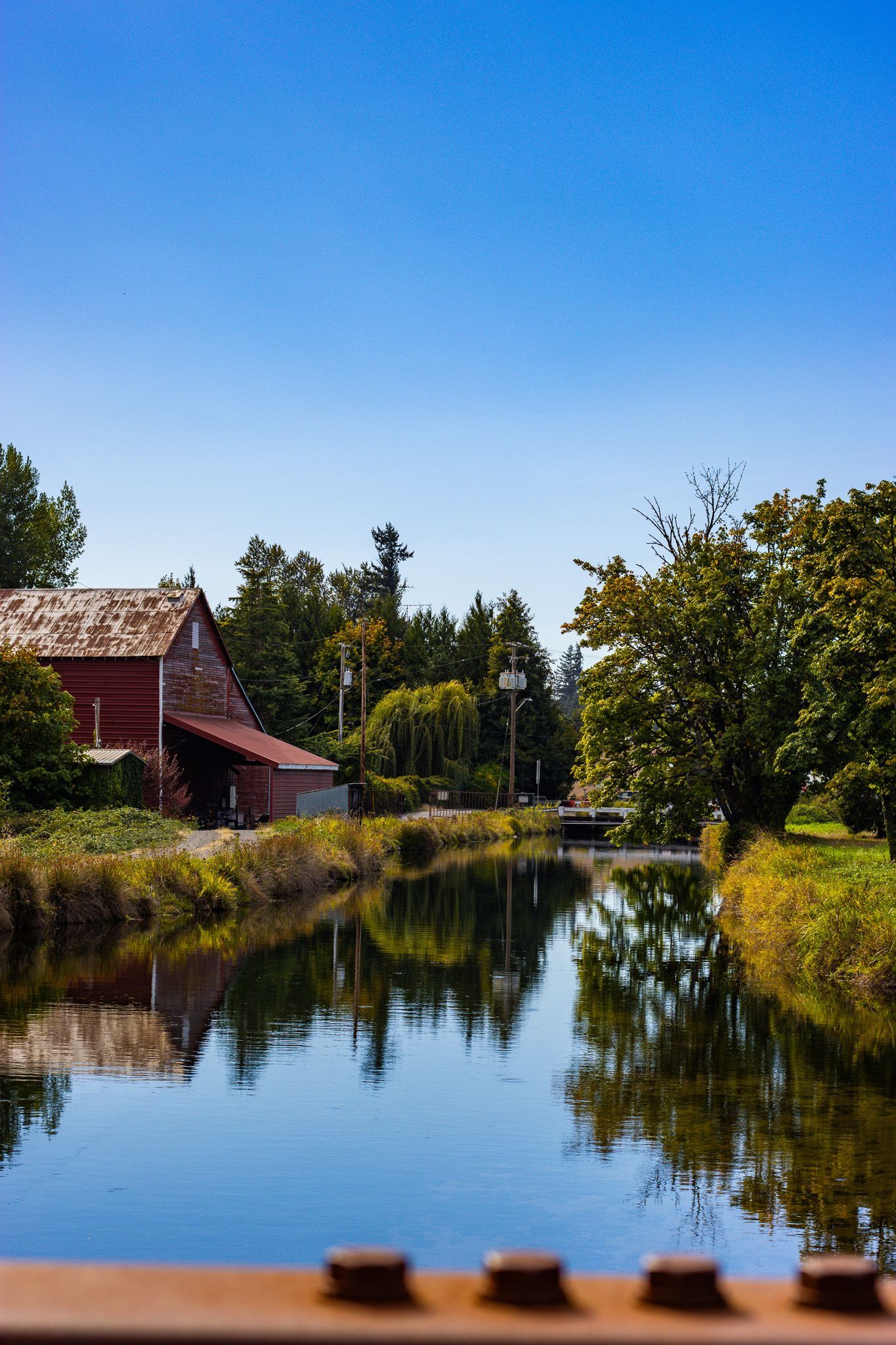 Scenic lake view with a rustic barn in Stayton Oregon United States, surrounded by calm water and natural countryside landscape.