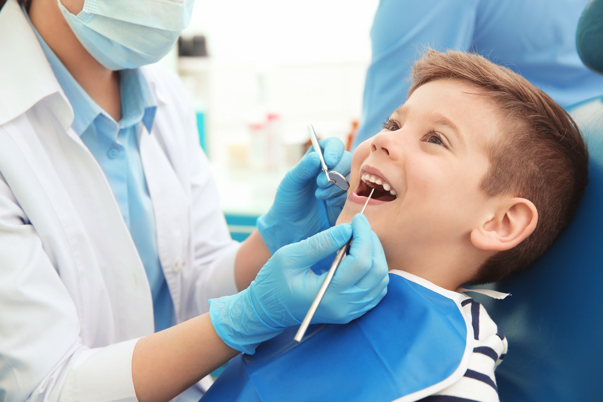 Un jeune garçon fait examiner ses dents par un dentiste.