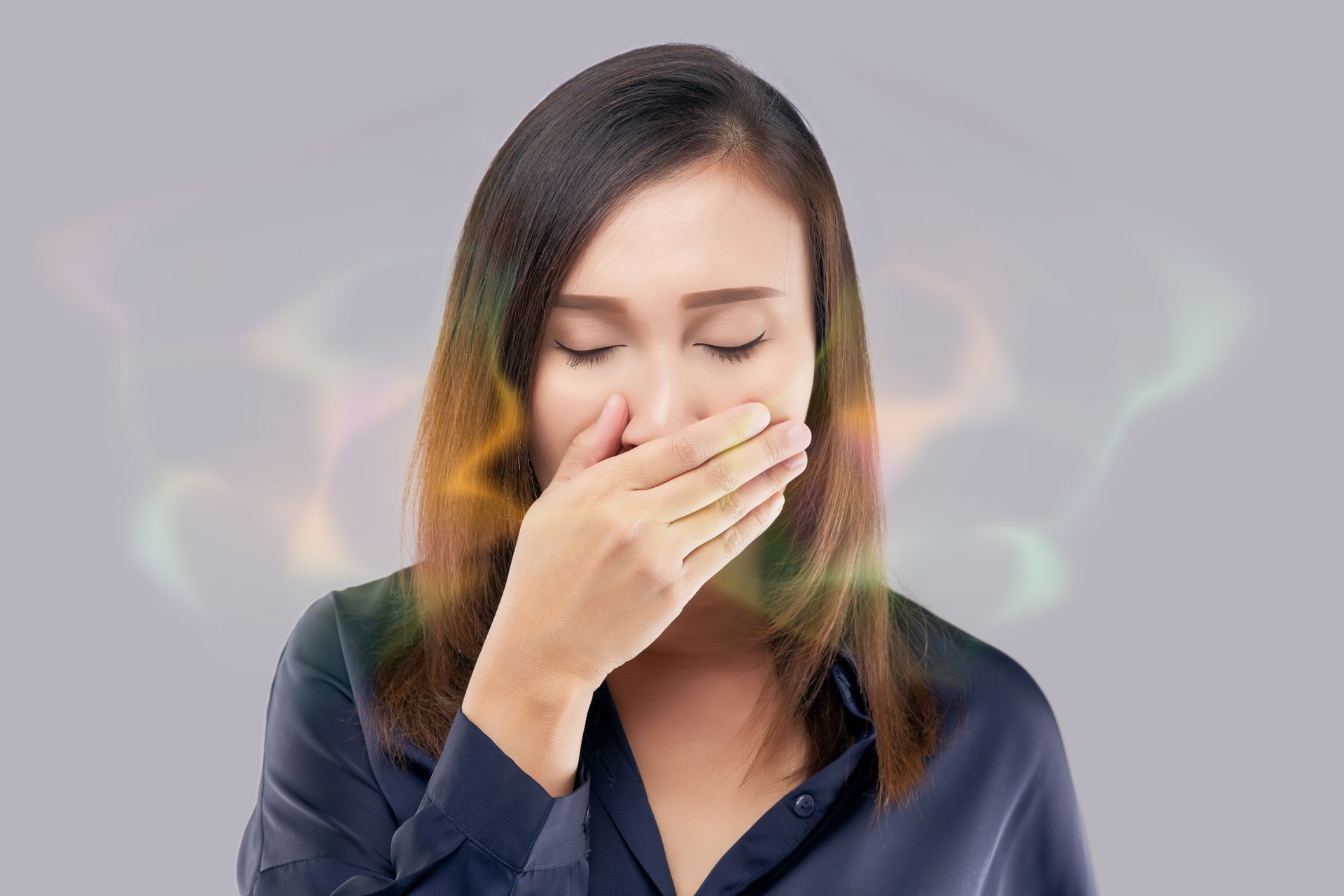 Une femme se couvre la bouche avec sa main à cause d'une mauvaise odeur.