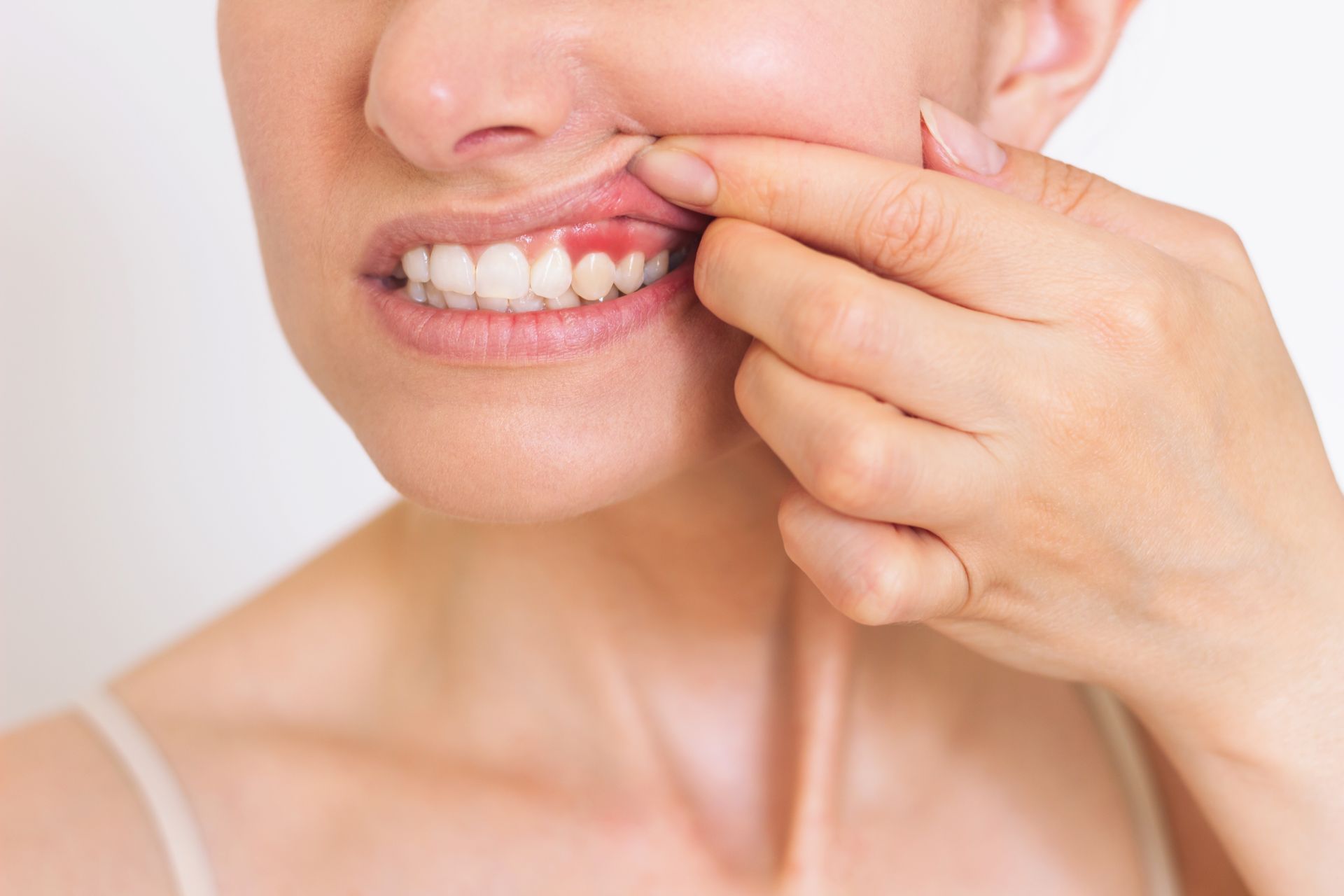 Une femme se tient la bouche de douleur à cause d'un mal de dents.