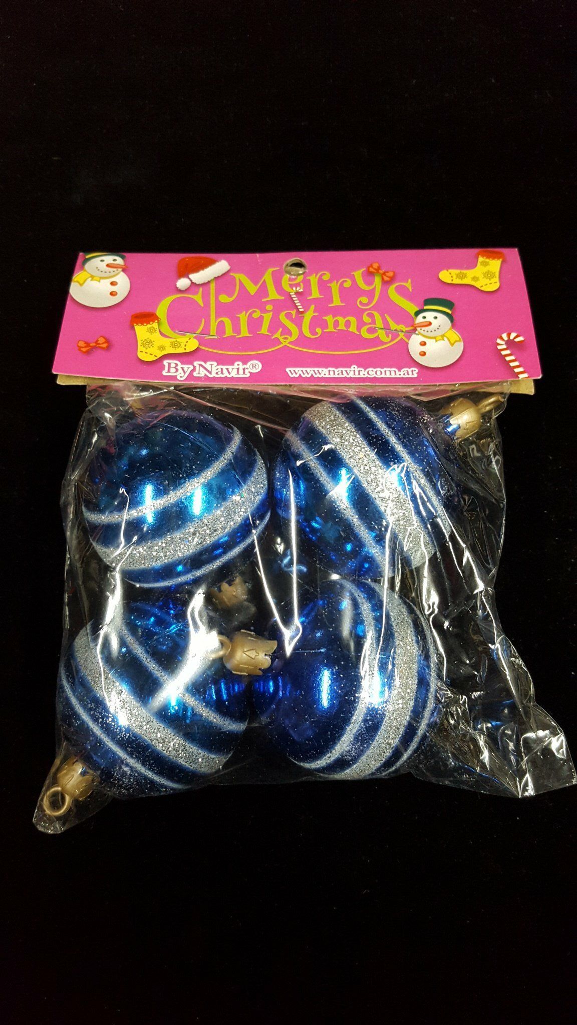 Bolsa transparente con adornos navideños azules y blancos y una tarjeta rosa con la leyenda 