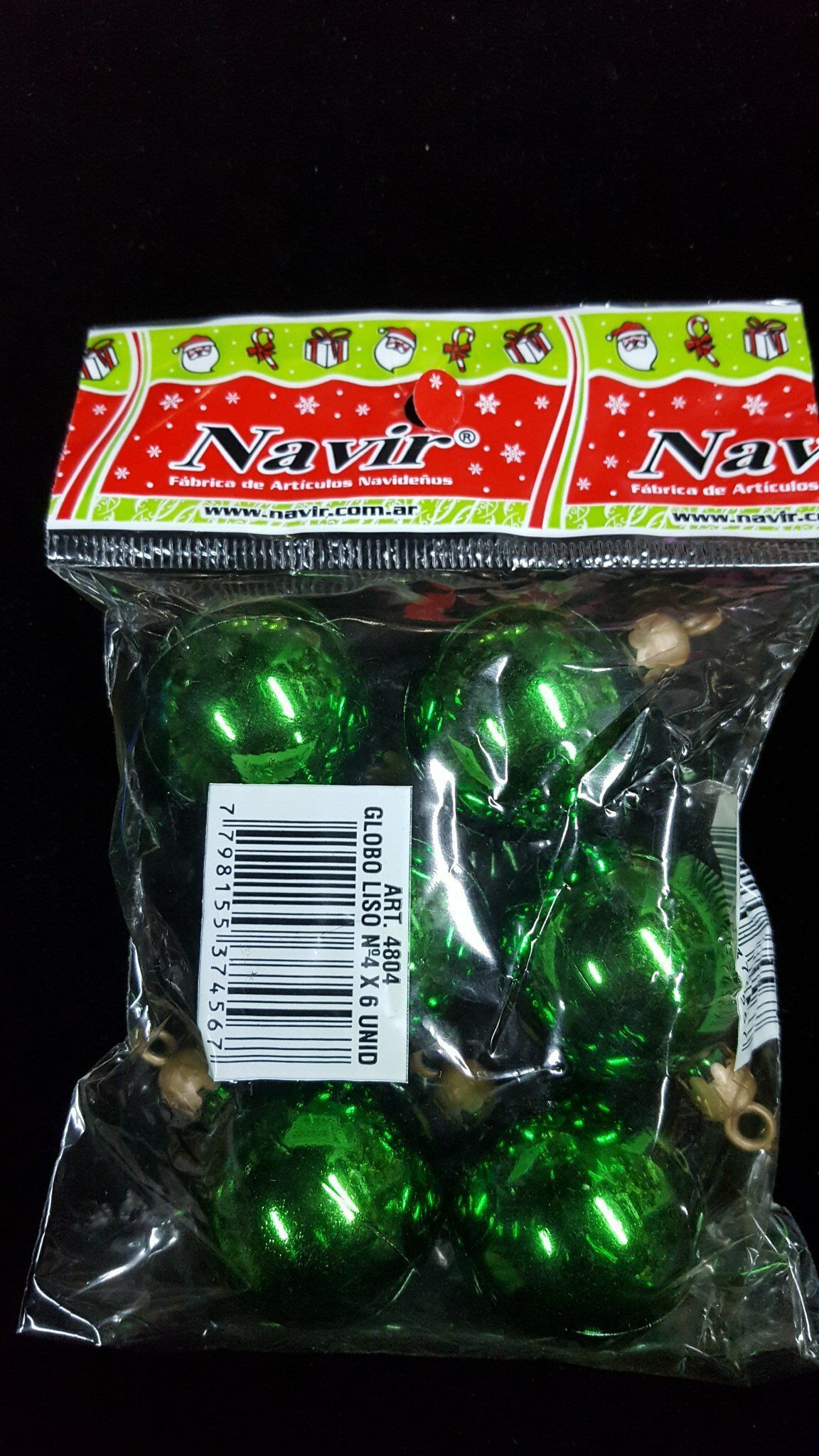 Bolsa de plástico transparente con adornos navideños verdes brillantes, etiqueta roja y verde y código de barras.