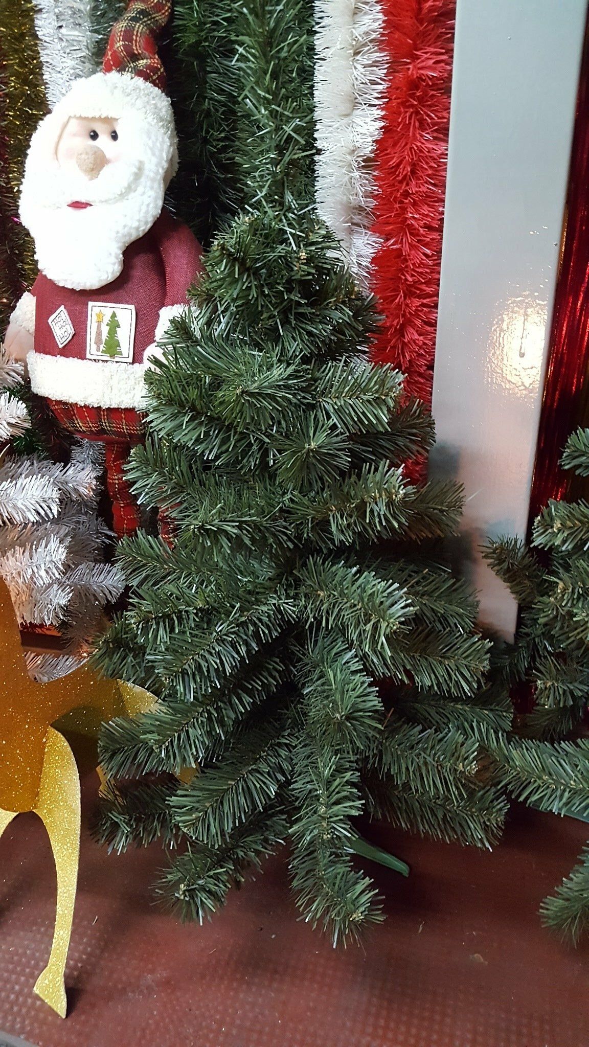 Árbol de Navidad artificial junto a la decoración de Papá Noel y la decoración navideña roja y blanca en el interior.
