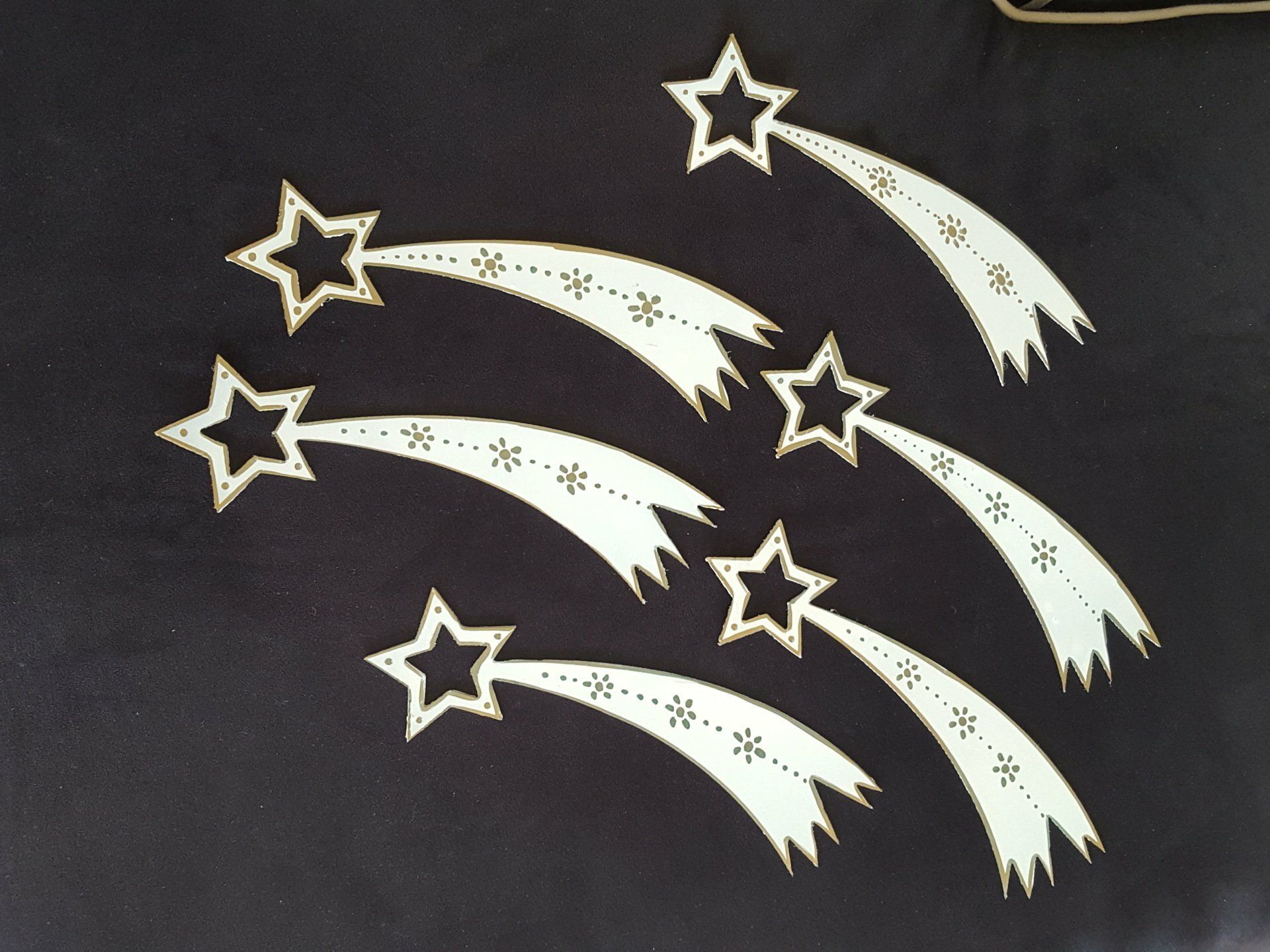 Estrellas fugaces blancas con cometas en estela sobre un fondo negro.