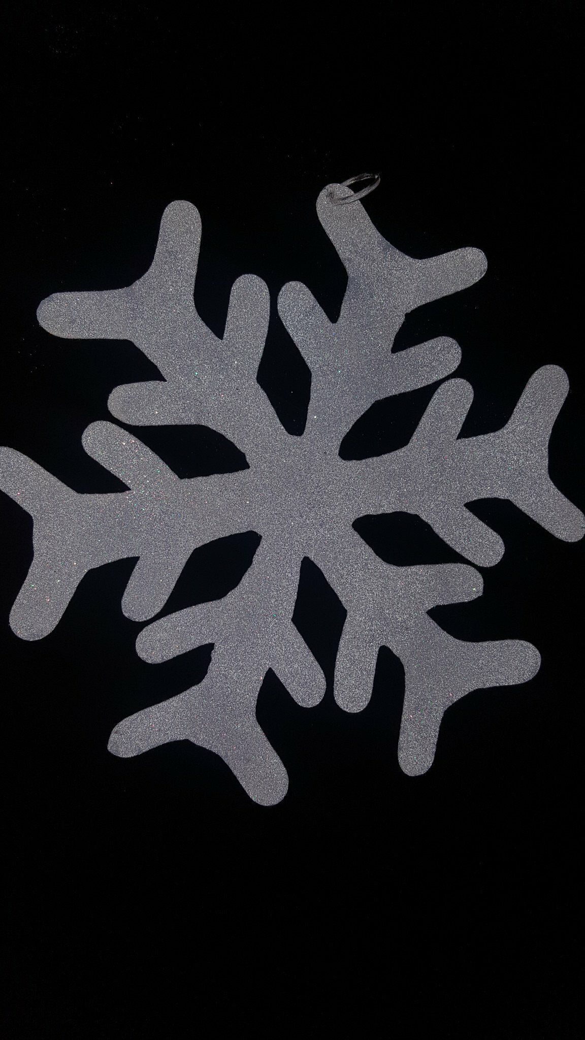 Silueta de copo de nieve blanco sobre fondo negro
