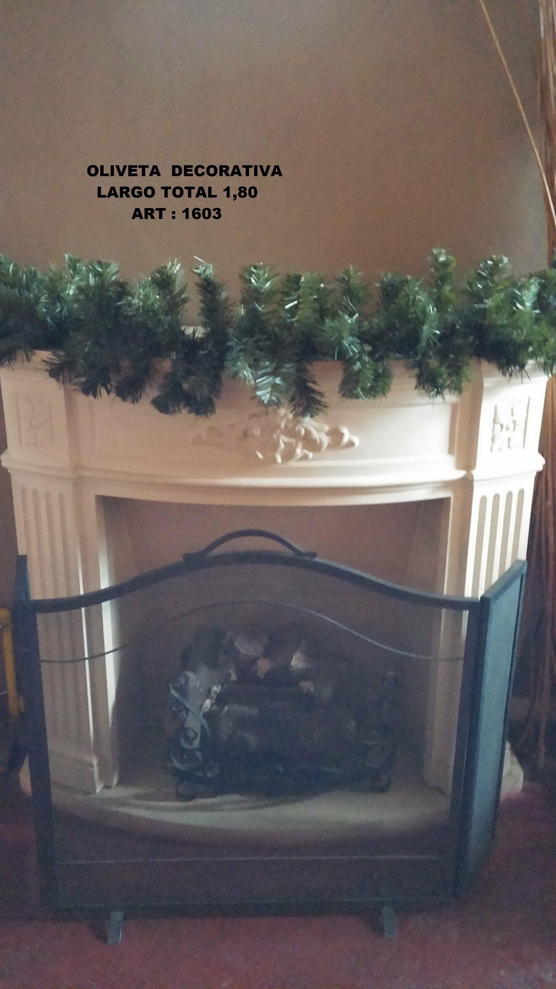Repisa de chimenea blanca decorada con guirnalda verde y una pantalla de chimenea negra en una habitación.