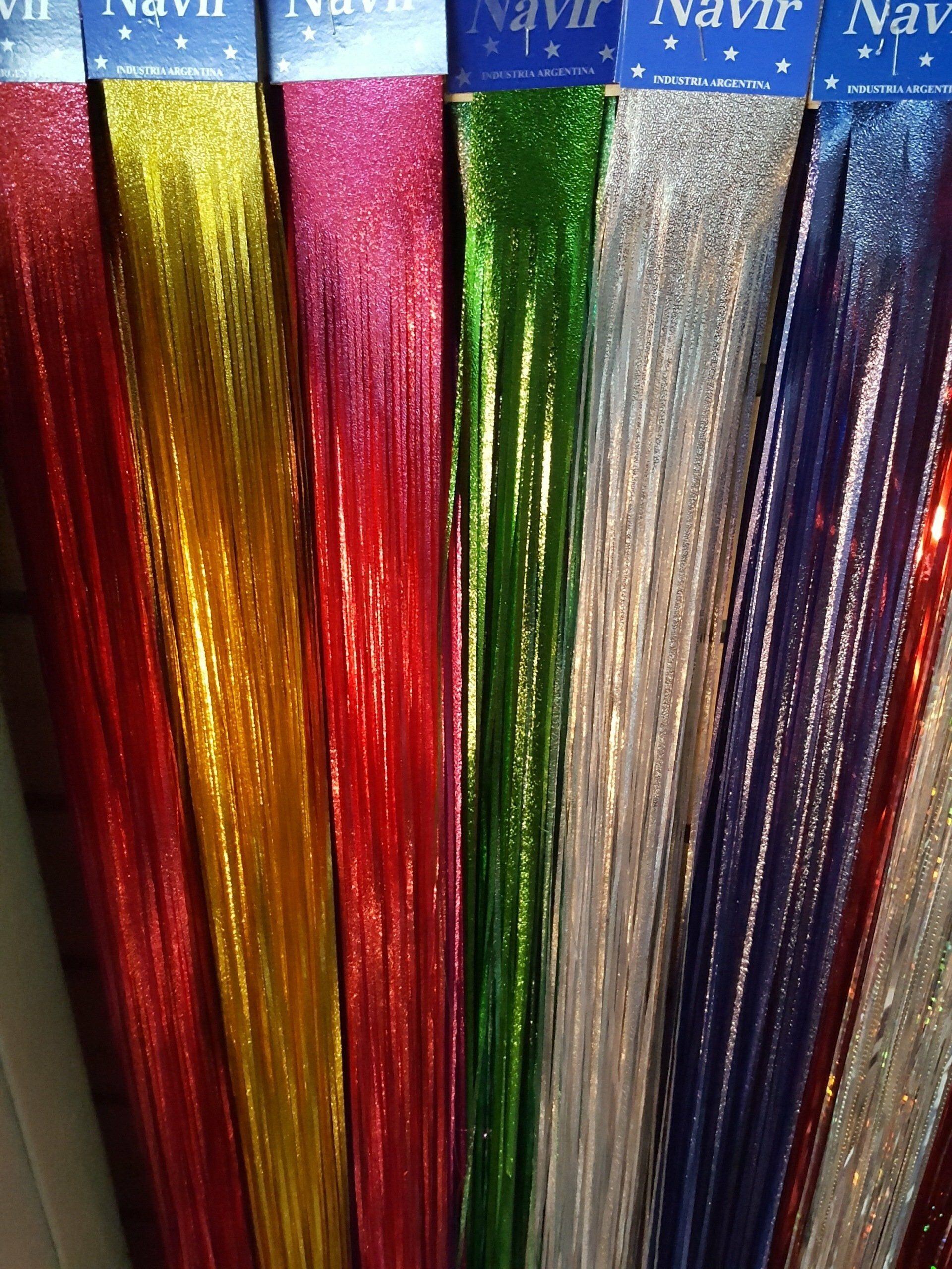 Hilos de oropel metálico de colores azul, dorado, rojo, verde, plateado y morado que cuelgan verticalmente.