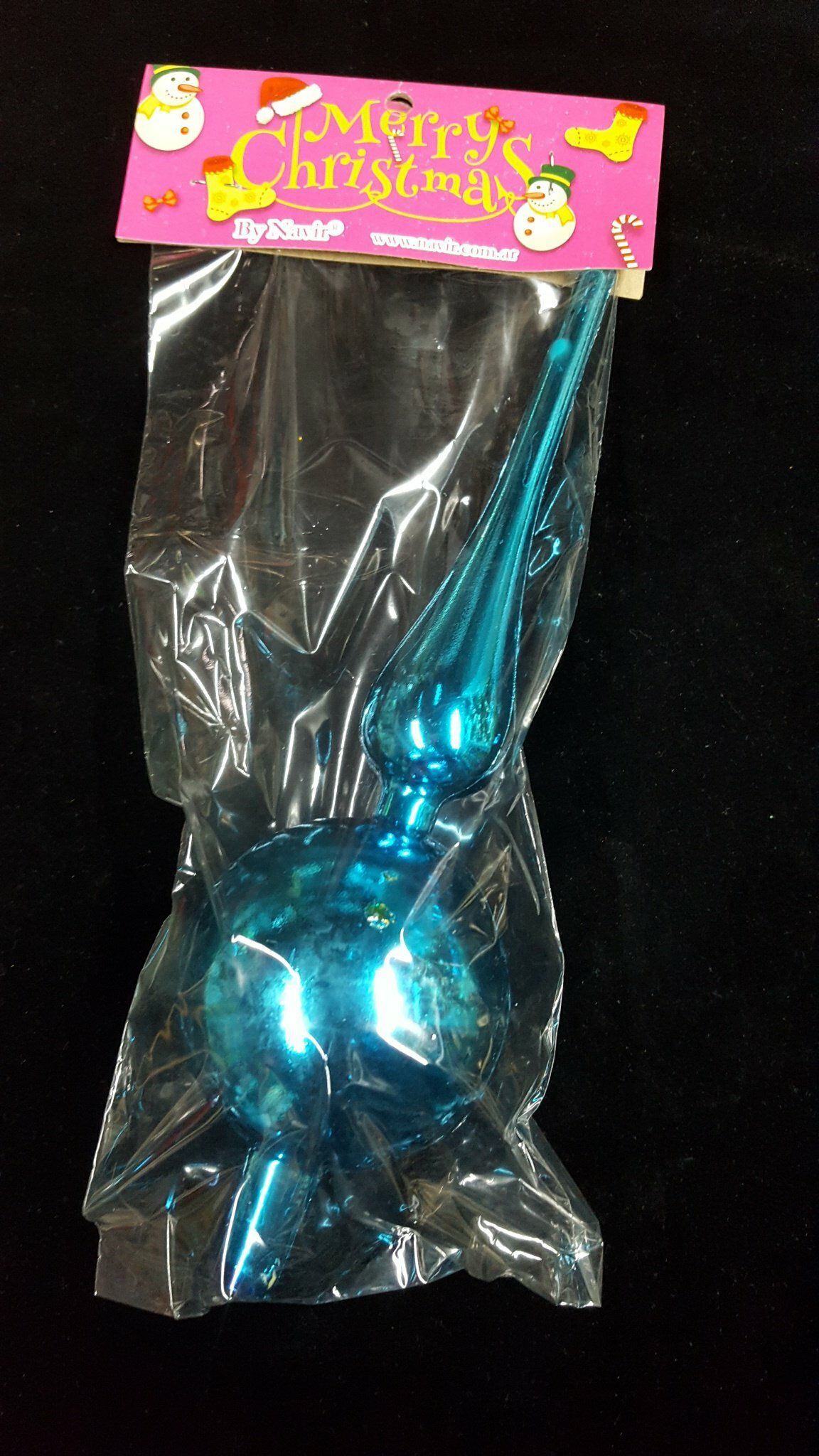 Adorno navideño azul metalizado en un embalaje de plástico transparente con una tarjeta navideña rosa.