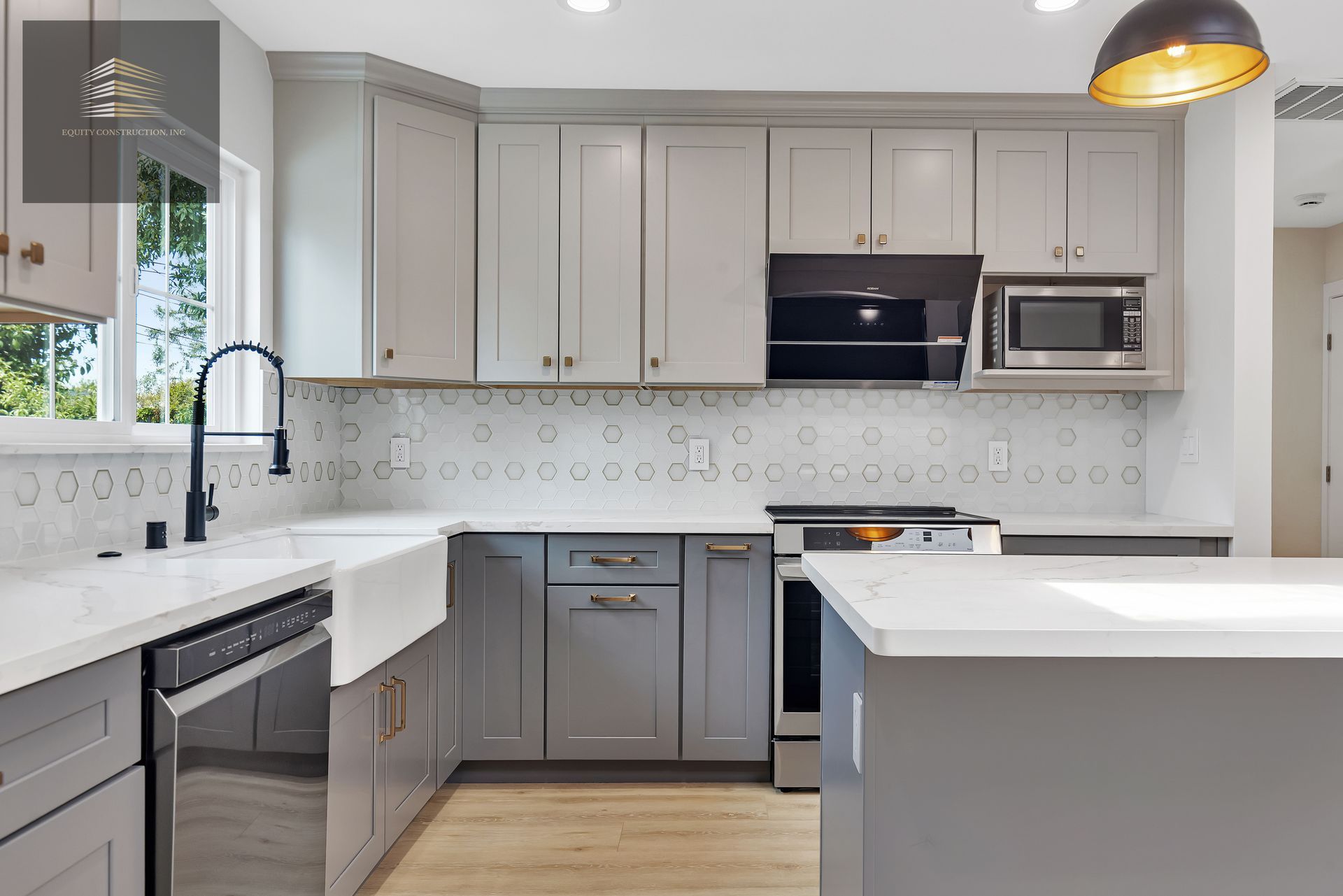 Gray kitchen with white countertops, stainless steel appliances, and a black faucet.