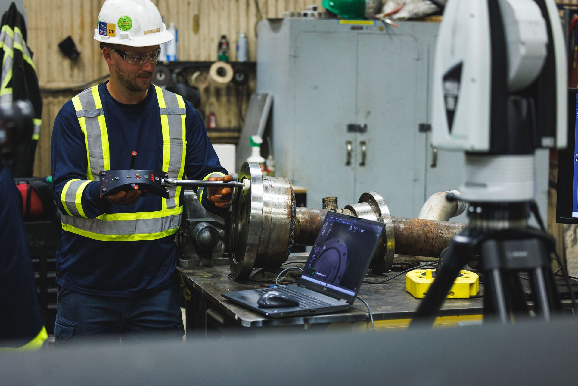 Un homme portant un casque travaille sur une machine dans une usine.