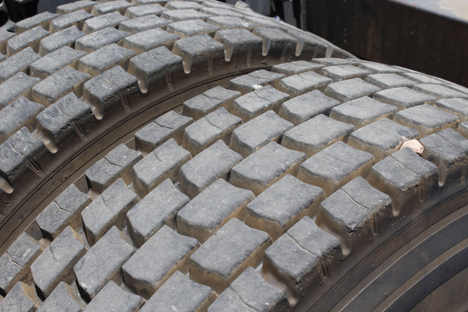 A close-up view of the tread pattern on two side-by-side, heavy-duty truck tires.