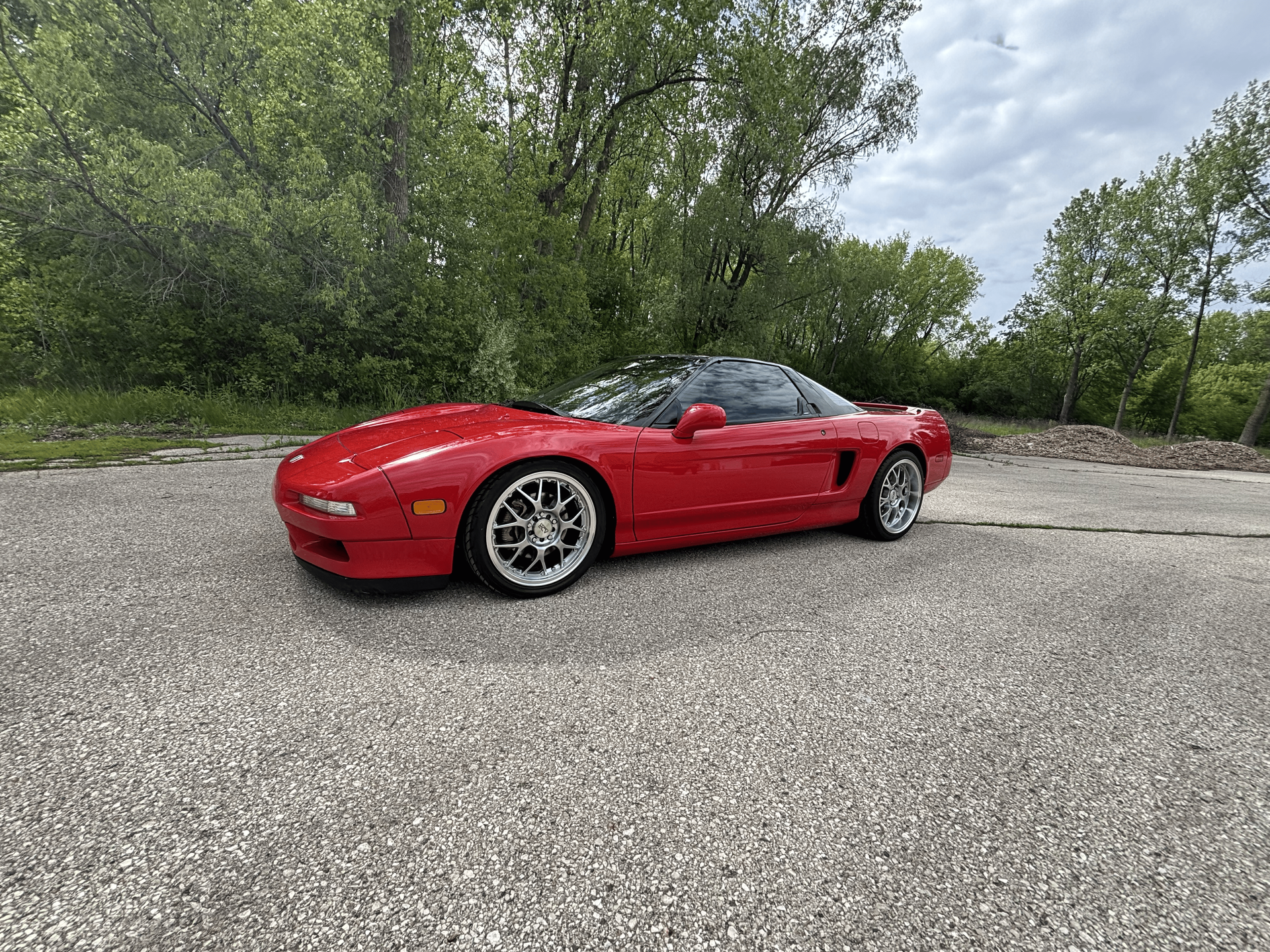 A red sports car is parked on the side of the road.