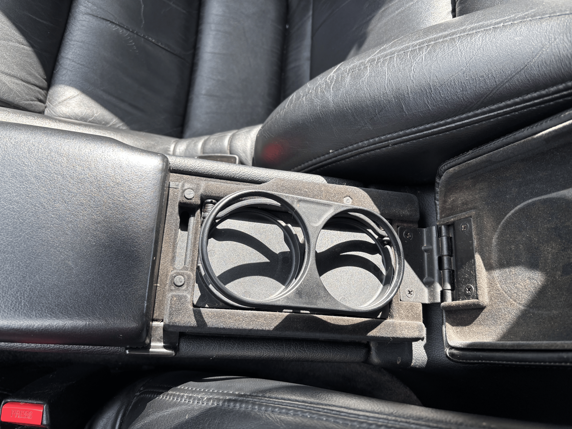 A car console with two cup holders in it